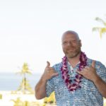 Adult man on Hawaiian vacation wearing a fresh orchid lei
